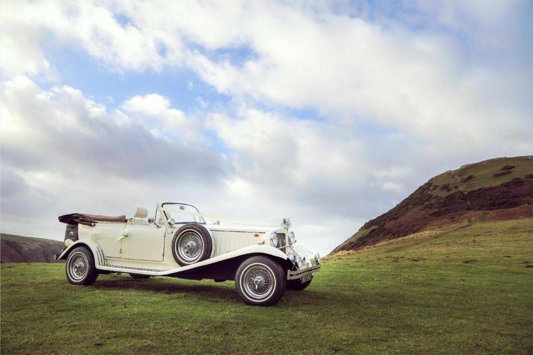 The Ceir y Cardi 1977 Beauford wedding car parked on a Welsh hillside above the coast